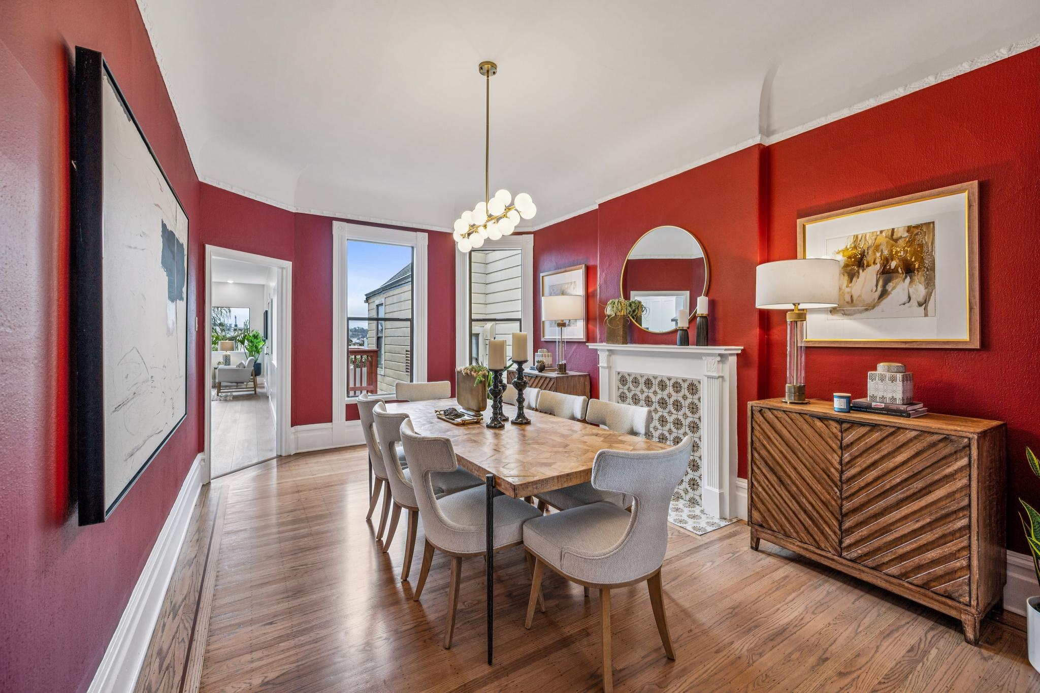 Red dining room with original fireplace surround and crown detail in a San Francisco Victorian
